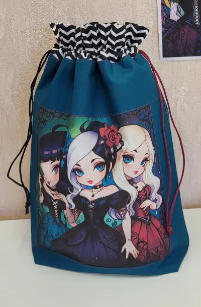 Pochette “Trio Enchanté” – Style manga & fantasy** Craquez pour cette pochette à cordon illustrée d’un trio de filles au style féérique et gothique. Pratique, originale et pleine de caractère, elle est parfaite pour ranger vos petits trésors avec une touche de magie.