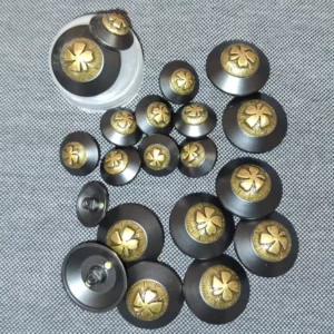 Bouton noir et doré motif trèfle – 15 & 24 mm – pour vestes, manteaux ou couture haute gamme.