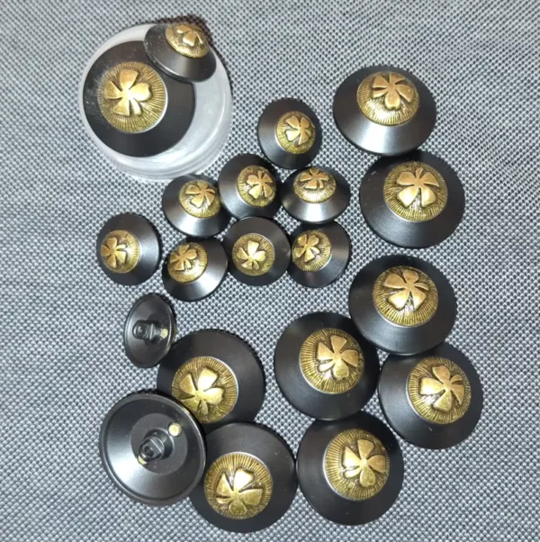Bouton noir et doré motif trèfle – 15 & 24 mm – pour vestes, manteaux ou couture haute gamme.